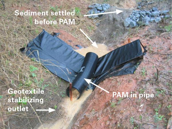 A check dam system using a length of corrugated pipe to protect a PAM log from heavy sediment (check dams); the pipe also provides a mixing zone and prevents the log from being exposed to drying conditions.